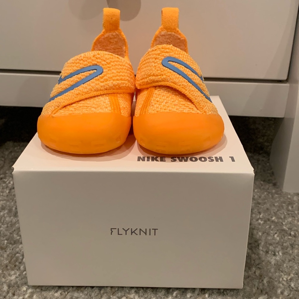 Orange Nike toddler walking shoes.